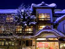 雪景色とも調和し風情ある木造三階建て総けやき造り本館正面玄関。「日本温泉遺産を守る会」認定。 藤三旅館 プランをみる